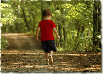 Little boy walking down the road.